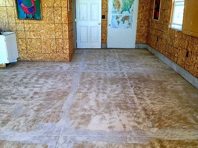Cracked and patched basement slab before coating